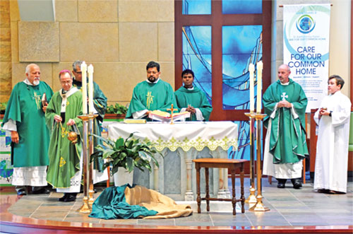 Archbishop Charles C. Thompson incenses the altar during a Care for Creation Mass at St. Bartholomew Church in Columbus on Sept. 24. Pictured behind the archbishop are Deacons William Jones, left, Jorge Sanchez and Juan Carlos Ramirez, Father Ashok Valabazzi, Father Christopher Wadelton and altar server Eero Haywood. (Photo by Natalie Hoefer)