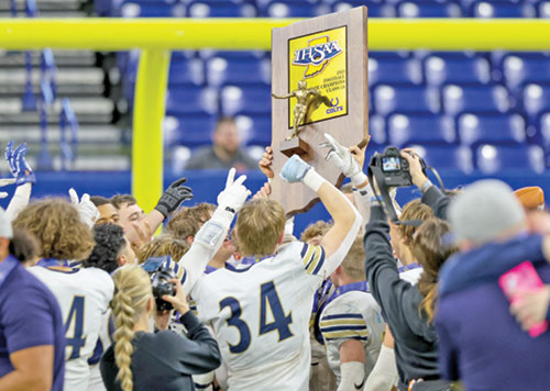 Members of the football team of Our Lady of Providence High School in Clarksville raise Indiana’s Class 1A state championship trophy in joy. (Photo courtesy of Jeff McKinley)