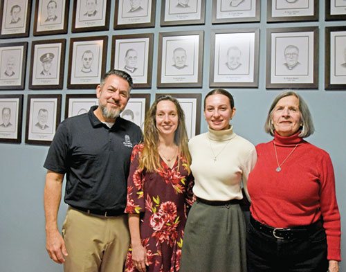 From left, Scott, Kenna and Mila Esposito pose with Judy Jackson on Feb. 7 at St. Bartholomew Parish in Columbus after the unveiling and blessing of drawings that Mila created of priests who have served as pastors in Columbus since 1841. Jackson was a mentor for Mila in the creation of the drawings. (Photo by Sean Gallagher)