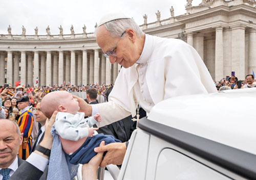 During his first general audience on May 21, Pope Leo XIV reaches for 6-week-old Laurence Brown to bless him. Laurence is the son of Dr. Brandon and Dr. Arielle Brown of SS. Peter and Paul Cathedral Parish in Indianapolis. (Photo courtesy of the Vatican)