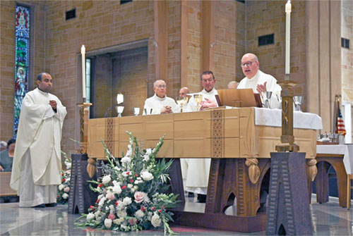 Msgr. William F. Stumpf, archdiocesan vicar general, right, prays the eucharistic prayer during a Sept. 13 Mass at St. Théresè of the Infant Jesus (Little Flower) Church in Indianapolis to celebrate the 100th anniversary of the Indianapolis East Deanery faith community’s founding. Concelebrating the Mass are, from left, Father Jude Meril Sahayam, Little Flower’s administrator, and retired Father Robert Gilday. Deacon Gary Blackwell, second from right, assists at the Mass. (Submitted photo by Caleb Baue)