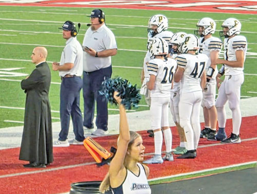 During most football games, Father Adam Ahern offers a presence to members of the team of Our Lady of Providence High School in Clarksville. (Submitted photo)