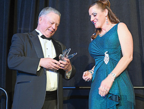 Mark Casper, agency director of St. Elizabeth Catholic Charities in New Albany, admires the Shepherd of Hope Award presented to him by the agency&rsquo;s development director Leah Alexander during a gala to raise funds for the agency at the Galt Houe Hotel in Louisville, Ky., on April 16. (Photo by Natalie Hoefer)