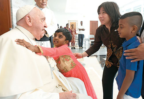 Pope Francis receives a hug from a child as he meets migrants, refugees, orphans, the elderly and the sick at the apostolic nunciature in Jakarta, Indonesia, on Sept. 3, 2024. On Feb. 11, the pope issued a letter to bishops in the U.S. urging them and all people of goodwill to advocate for immigration policies that protect the dignity of all people. (CNS photo/Vatican Media)