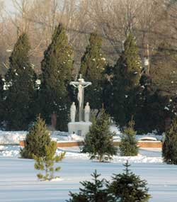 Morning light shines on Dec. 12 on a crucifix and other statuary in the snow-covered cemetery at Our Lady of Grace Monastery in Beech Grove. The Benedictine women’s religious community recently celebrated the 50th anniversary of its founding. 