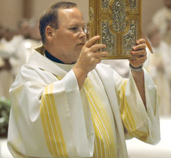 Deacon Randall Summers carries a Book of the Gospels during the chrism Mass celebrated on April 3 at SS. Peter and Paul Cathedral in Indianapolis. Deacon Summers will be ordained to the priesthood at the cathedral on June 2.