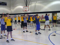 Mike Prior, Indianapolis Colts youth football commissioner, right, demonstrates an exercise to St. Anthony of Padua School eighth-grade students during the Colts Fitness Camp session on Nov. 27.	