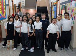 St. Philip Neri School students pose for an informal class picture on their way to lunch on Jan. 10 at the Indianapolis East Deanery grade school. Campus minister Mary McCoy stands in the hallway behind them. This year, 93 percent of St. Philip Neri’s students are Hispanic. Five years ago, that figure was about 25 percent. English as a New Language programs and bilingual teachers are helping Latino students and their families acclimate to a new language and culture. (Photo by Mary Ann Wyand)	