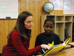 Central Catholic School third-grade teacher Rachel Brubaker helps Cedric Georges with a reading assignment on Jan. 10 at the Indianapolis South Deanery grade school. Cedric and his sister, Sabrina, a fifth-grader, moved from Cape Haitian, Haiti, to Indianapolis last August with their mother, Rose Georges, and have excelled in their school work thanks in part to English as a New Language classes. (Photo by Mary Ann Wyand) 
