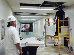 Construction workers make improvements in a hallway at Father Thomas Scecina Memorial High School in Indianapolis on July 23. The Indianapolis East Deanery interparochial high school is using a $1 million allocation of a Lilly Endowment grant to the Archdiocese of Indianapolis to make capital improvements. (Photo by Sean Gallagher) 