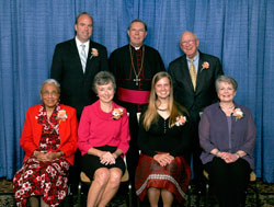 Spirit of Service Award winners, seated from left, are Maxine Ferguson, Lynne O’Day, Jenna Knapp and Patty Schmalz. Standing, from left, are Pat Sullivan, Archbishop Daniel M. Buechlein and Robert Sullivan. (Photo by Richard Clark) 