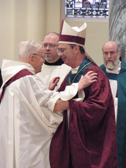 Benedictine Father Theodore Heck gives the sign of peace to Benedictine Archabbot Justin DuVall during a Mass at the Archabbey Church of Our Lady of Einseideln on Jan. 21, 2005. During the liturgy, Archabbot Justin, who was elected the leader of Saint Meinrad Archabbey on Dec. 31, 2004, was ritually blessed and took office. Father Theodore died on April 29 at the age of 108. He was the oldest Benedictine monk in the world. (File photo by Sean Gallagher) 