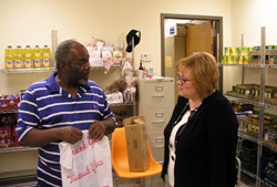 As the new director of the Crisis Office, Stephanie Davis, right, leads a team of staff members and volunteers who work to bring hope and help to people in need. Here, she talks to volunteer Jerry Thomas in the food pantry of the Crisis Office, an emergency assistance program of Catholic Charities Indianapolis. (Photo by John Shaughnessy) 