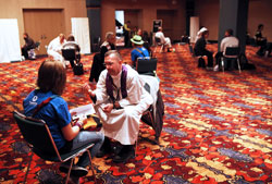 Priests listen to teenagers’ confessions in a room at the Indiana Convention Center on Nov. 18 during the National Catholic Youth Conference in Indianapolis. (Photo by Rich Clark)