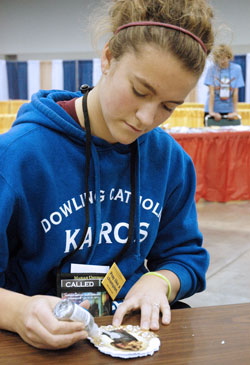 Rachel Schmidt, 17, a member of St. Pius X Parish in Urbandale, Iowa, creates a Christmas card for an American soldier serving overseas during the holidays—part of the service emphasis that marked the National Catholic Youth Conference in Indianapolis on Nov. 17-19. (Photo by John Shaughnessy)