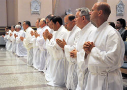18 deacon candidates kneel on the floor at SS. Peter and Paul Cathedral in Indianapolis on June 23 during their ordination Mass. Bishop Christopher J. Coyne, apostolic administrator, ordained 16 of the men as permanent deacons. Two men were ordained as transitional deacons and expect to be ordained as priests next year. (Photo by Sean Gallagher)