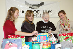 The Food Link pantry is hoping to provide toys for nearly 1,000 children from Indianapolis families in need this Christmas. Maria Sasso, from left, April Sasso, Wynn Tinkham and Willa Sasso, members of St. Luke the Evangelist Parish in Indianapolis, sort some of the toys that will be distributed on Dec. 22 at the food pantry that Dick and Wynn Tinkham started 30 years ago. (Photo by John Shaughnessy)