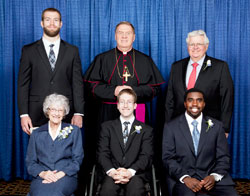 Catholic Charities Indianapolis presented four individuals with Spirit of Service Awards during an April 30 dinner in Indianapolis. Award recipients, seated from left, are Franciscan Sister Norma Rocklage, Zach Smith and Gene Hawkins. Standing, from left, are featured speaker Jack Doyle, Archbishop Joseph W. Tobin and award winner Steve Rasmussen. (Photo by Rich Clark)