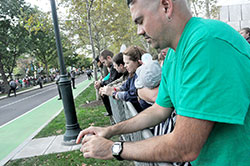 Scott Seibert, left, coordinator of marriage and family enrichment for the archdiocesan Office of Pro-Life and Family Life, David Dellacca, DeInda Dellacca, Renee Odum, Asa Odum (both partially obscured) and Shane Odum pray on Sept. 26 while standing along a barricade next to the Benjamin Franklin Parkway in Philadelphia prior to the Festival of Families, which was attended by Pope Francis. (Photo by Sean Gallagher)