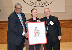 Providence Sister Tracey Horan receives the Catholic Campaign for Human Development’s (CCHD) 2017 Cardinal Bernardin New Leadership Award from CCHD director Ralph McCloud, left, and Bishop David P. Talley of Alexandria, La., at the Archbishop Edward T. O’Meara Catholic Center in Indianapolis on June 14. (Photo by Natalie Hoefer)