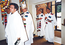 Then-Father-Charles Thompson processes in to celebrate his first Mass on May 30, 1987, at St. Bernard Church in Louisville, Ky. Pictured, from left, Father Joseph Fowler, the parish’s pastor; then-Bishop Daniel M. Buechlein of Memphis, Tenn.; and Father Thompson. (Photo courtesy Father Dale Cieslik)