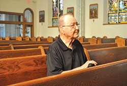 Frank Savage sits on Sept. 28 in St. Lawrence Church in Lawrenceburg. The 96-year-old is a lifelong member of St. Lawrence Parish, which is celebrating the 175th anniversary of its founding. He lived through a massive flood in 1937 that ravaged the parish and Lawrenceburg, and joined parishioners in the following decades to help it grow. (Photo by Sean Gallagher)