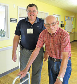 Compassionate Visitor volunteer Mike Fronckowiak, left, a member of St. Gabriel Parish in Connersville, walks on Aug. 3 with Earl Schneider, a resident he visits weekly at a nursing home in Connersville. (Submitted photo)