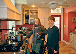 Suzanne Konnersman, left, and her sister Hilary Konnersman stand in their kitchen where Suzanne has learned to cook traditional, healthy food. Suzanne started the Kessing Haus Café in Oldenburg as a place for the community to gather in a unique coffee shop. (Photo by Jennifer Lindberg)
