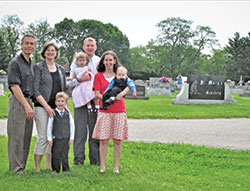Members of St. Mary Parish’s Miscarriage Ministry in Greensburg stand at the spot of the soon-to-be built Little Souls Cemetery. Pictured are Dan, left, and Diane Scheidler; John Harpring; Chris Harpring, holding Philomena Harpring; and Rebecca Harpring holding Louis Harpring. The families are spearheading the ministry at the parish to help women know they can bury their miscarried babies. (Submitted photo)