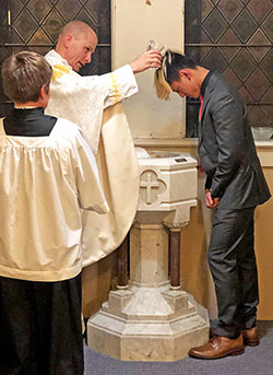Above, Father John Hollowell baptizes Phil Chung during the Easter Vigil Mass at St. Paul the Apostle Church in Greencastle on April 20. (Submitted photo)