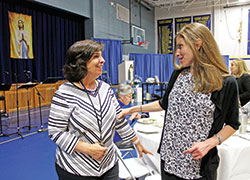 Mother and daughter Teresa, left, and Brigette Schutzman, members of St. Luke the Evangelist Parish in Indianapolis, greet each other in the parish’s school gymnasium during a Mary’s WAY event on Oct. 24. (Submitted photo by Victoria Arthur)