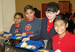Sixth-graders Yasmin Carlos, left, Miguel Macias, Jonathan Villegas and David Anzurez line up for lunch at St. Anthony School in Indianapolis. (Photo by John Shaughnessy)