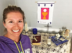 Allison Meyers stands in front of a personal prayer altar she created in her home, which includes her first Communion banner, as a way of keeping her focus on her relationship with God during the coronavirus pandemic. (Submitted photo)