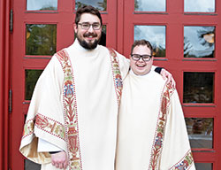 Transitional Deacons Michael Clawson, left, and Matthew Perronie smile while posing on April 10 outside the Archabbey Church of Our Lady of Einsiedeln in St. Meinrad. The two were ordained transitional deacons for the archdiocese that day after experiencing a challenging year of priestly formation in the midst of the coronavirus pandemic. Both have received full doses of a coronavirus vaccine. (Photo courtesy of Saint Meinrad Archabbey)