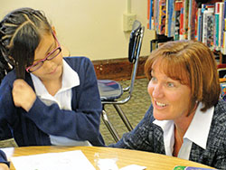 In this photo from 2013, then-assistant superintendent of Catholic schools Mary McCoy returned for a visit to St. Philip Neri School in Indianapolis, where she had previously served as principal. Here, she visits with Aylee Gomez, then a student at the school. (Submitted photo)