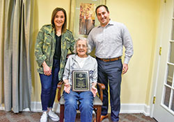Family members of the late Joe Cathcart are all smiles as they pose with the plaque honoring the late beloved Catholic Youth Organization (CYO) football coach. Cathcart’s daughter Kelly, left, his mother Joyce and his son David received the plaque from Bruce Scifres, executive director of the archdiocese’s CYO. (Submitted photo)