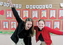 The smiles of Alexandra “Alex” Daley, left, and Ella Spoonmore show their close friendship, a friendship that has helped the two fifth-grade students at St. Charles Borromeo School in Bloomington lead drives that have collected nearly 10,000 pounds of food in the past two years to help families in southern Indiana. (Photo by John Shaughnessy)