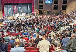 Some 1,200 men kneel in prayer during a Mass on Feb. 18 at East Central High School in St. Leon that was part of the eighth annual E6 Catholic Men’s Conference sponsored by All Saints Parish in Dearborn County. (Photo by Sean Gallagher)