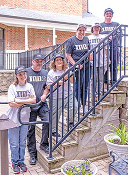 Six residents of the Village of Merici in Indianapolis—a Catholic-inspired place of hope and growth for adults with disabilities—showcase the hats and T-shirts that are part of a fundraising effort led by Cathedral High School grad and Cincinnati Bengals football player Ted Karras that has raised nearly $400,000 for the Village. The residents are Mary McClamroch, left, Jason Renie, Trese Mascari, Sarah Boyd, Angie Cain and Steve Mailloux.  (Submitted photo)