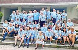 Participants, volunteers and catechists pose for a photo on July 23 at the Benedict Inn and Conference Center in Beech Grove after the 23rd annual summer Special Religious Education and Discipleship retreat for those with special needs. Among the catechists are Shannon Farrell, far left on fourth step, and archdiocesan special needs coordinator Jennifer Bryans, far right on fifth step. (Submitted photo)