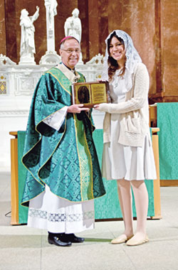 Sara Cabrera, a member of St. Thomas More Parish in Mooresville, receives the archdiocese’s Our Lady of Guadalupe Pro-Life Youth Award from Archbishop Charles C. Thompson during the annual Respect Life Mass at SS. Peter and Paul Cathedral in Indianapolis on Oct. 1. (Photo by Natalie Hoefer)
