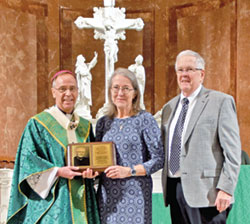Mary and Larry Dougherty, members of Immaculate Heart of Mary Parish in Indianapolis, receive the archdiocese’s Archbishop Edward T. O’Meara Respect Life Award from Archbishop Charles C. Thompson during the annual Respect Life Mass at SS. Peter and Paul Cathedral in Indianapolis on Oct. 1. (Photo by Natalie Hoefer)