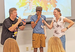 In her previous role as the director of youth ministry at Holy Spirit at Geist Parish in Fishers, Ind., in the Lafayette Diocese, Rachel Gilman leads a game of Name That Tune, using kazoos, with Lucas Hamilton, left, and Brian Belford, Jr. Gilman is now the new director of youth ministry for the Archdiocese of Indianapolis. (Submitted photo)