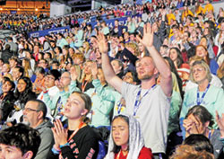 Participants in the National Catholic Youth Conference raise their hands in prayer during the closing Mass of the National Catholic Youth Conference on Nov. 18 in Lucas Oil Stadium in Indianapolis. (Photo by Mike Krokos)