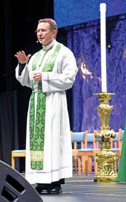 Bishop Andrew H. Cozzens of Crookston, Minn., speaks before the National Catholic Youth Congress’ closing Mass on Nov. 18 about next summer’s National Eucharistic Congress in Indianapolis. (Photo by Sean Gallagher)