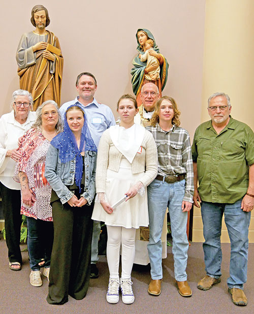 The McClain family members pose with Father Stephen Giannini, pastor of SS. Francis and Clare of Assisi Parish in Greenwood, and extended family members after the Easter Vigil Mass at SS. Francis and Clare of Assisi Church on March 31. At far left is John’s grandmother Phyllis Long, his mother Deborah Woodard, Jessie McClain, John McClain, Jewel McClain, Father Giannini, Steven McClain and John’s stepfather Mike Woodard. (Submitted photo)