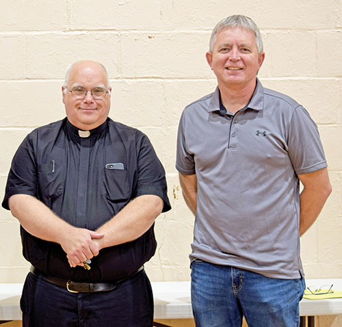 Benedictine Father Luke Waugh poses with Tim Davis, a member of St. Isidore the Farmer Parish in Perry County, in the parish center of St. Augustine Parish in Leopold after a synodal listening and dialogue session with members of those two parishes and Holy Cross Parish in St. Croix on April 24. (Submitted photos by Leslie Lynch)