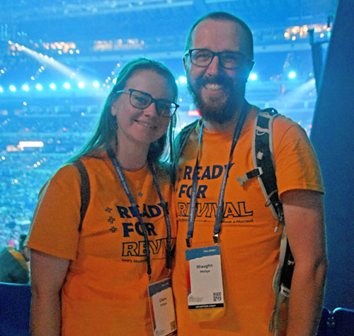 Newlyweds Claire and Shaughn Phillips, members of St. Joan of Arc Parish in Indianapolis, pose in Lucas Oil Stadium in Indianapolis on July 17 after the first revival session of the National Eucharistic Congress. The couple volunteered for the entirety of the July 17-21 gathering, including the day before and the day after the congress. (Photo by Natalie Hoefer)