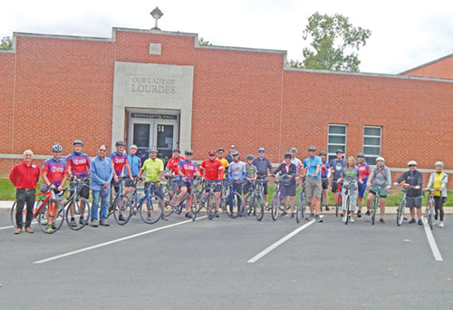 A group of cyclists taking part in the annual “Biking for Babies” event poses on Sept. 7 in the parking lot of Our Lady of Lourdes Parish in Indianapolis. (Photo by Mike Krokos)