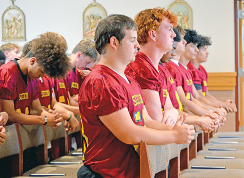 Members of the football team of Father Thomas Scecina Memorial High School in Indianapolis show their reverence and solidarity during a pre-game Mass in the school’s chapel on Sept. 19. (Photo courtesy of Katie Nelson)